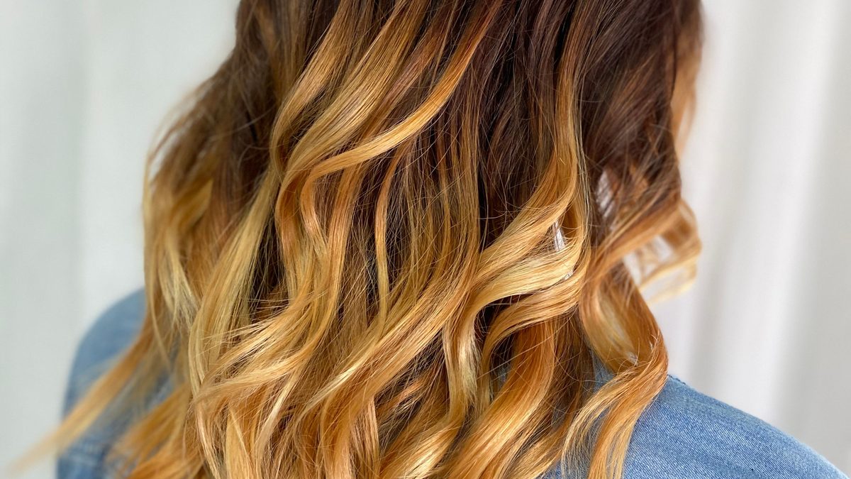 Lived-in blonde balayage with a shadowed root, styled in the salon