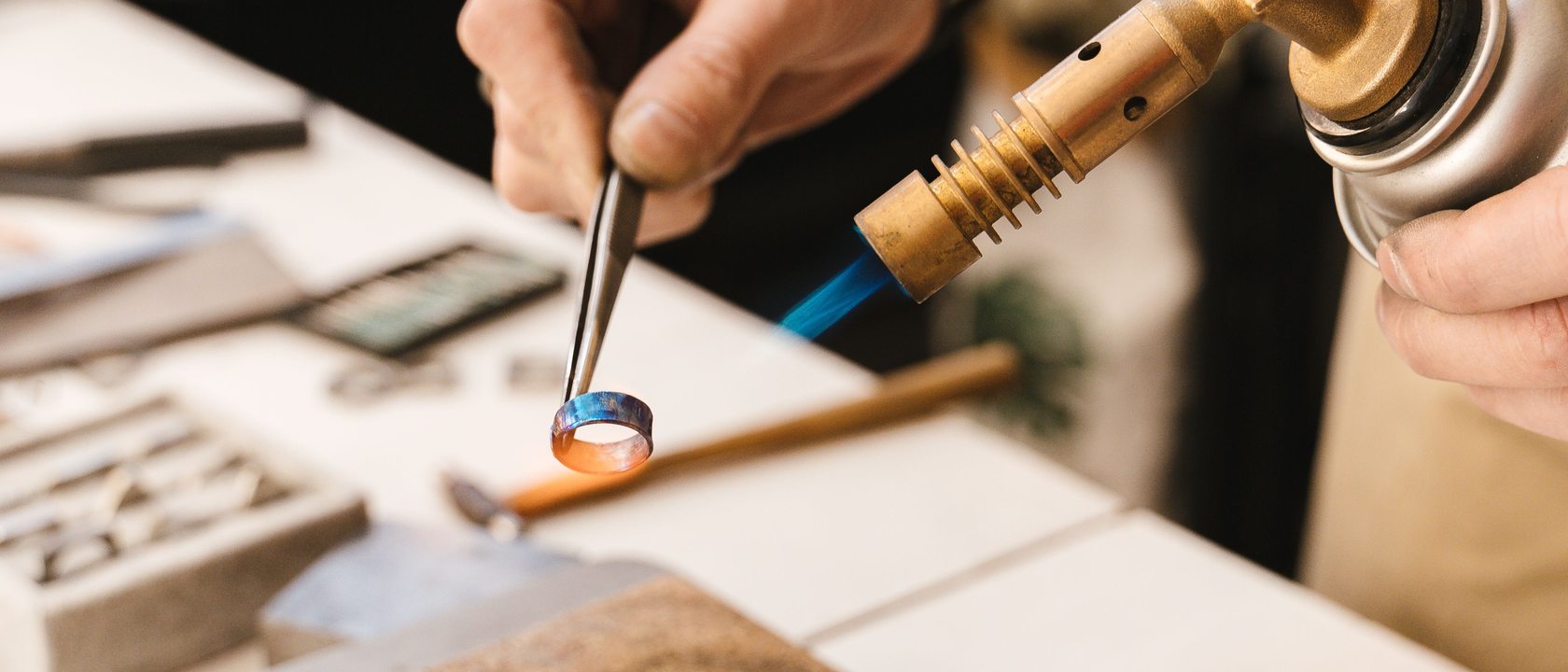 A bench jeweler setting a stone under the loupe at the Cary Street workbench