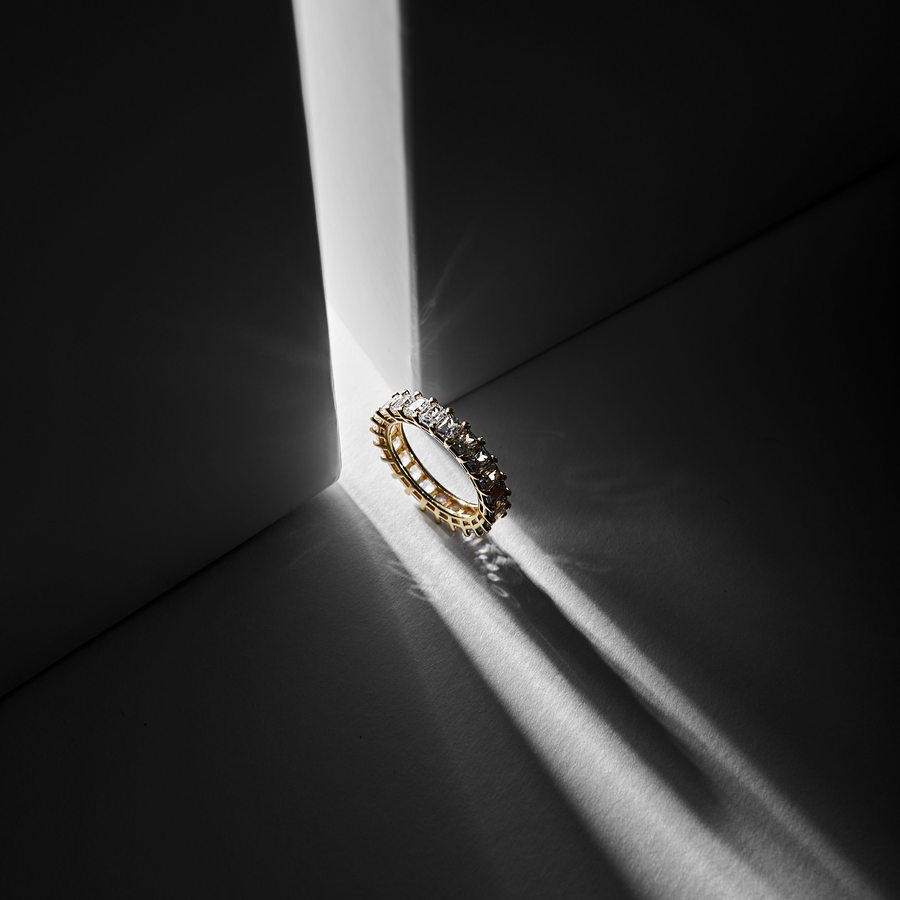 A pair of hand-forged platinum and gold wedding bands resting together in low light