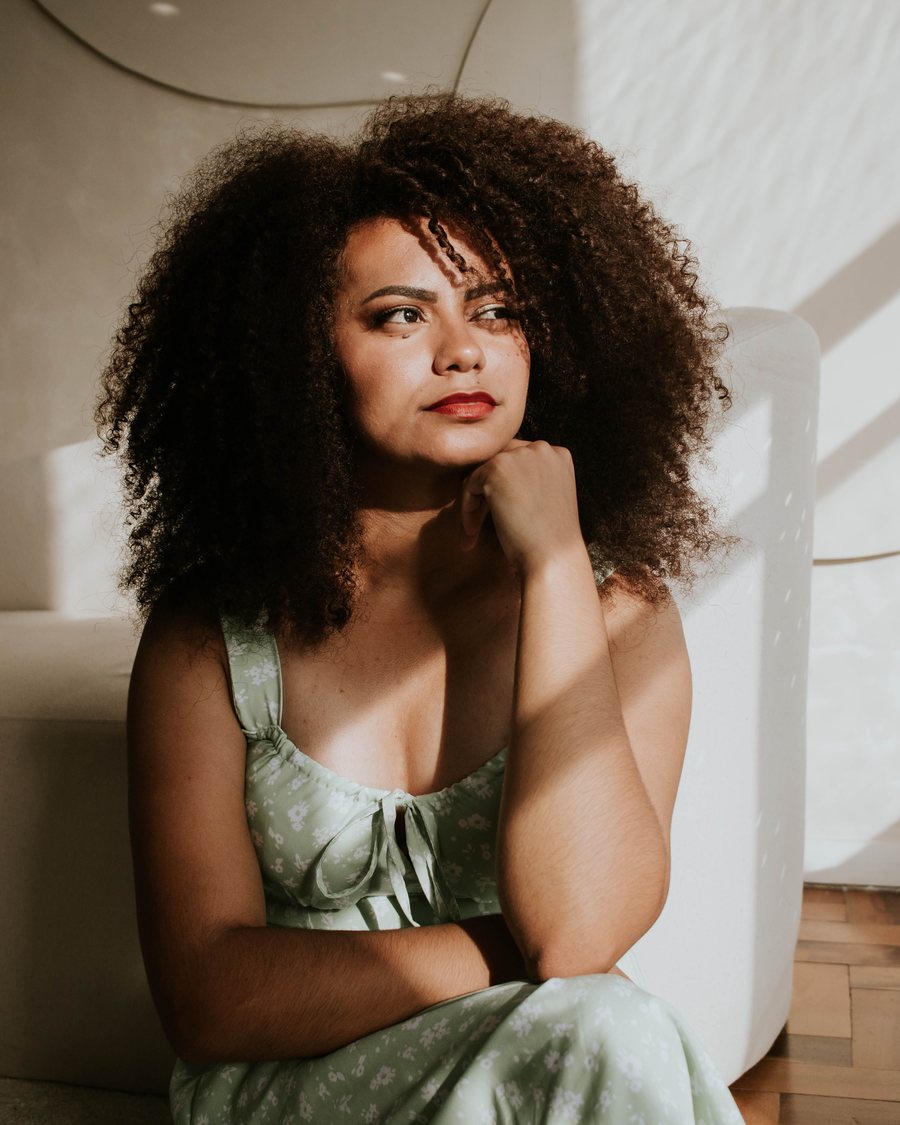 A woman sitting in warm afternoon light, thinking through what comes next