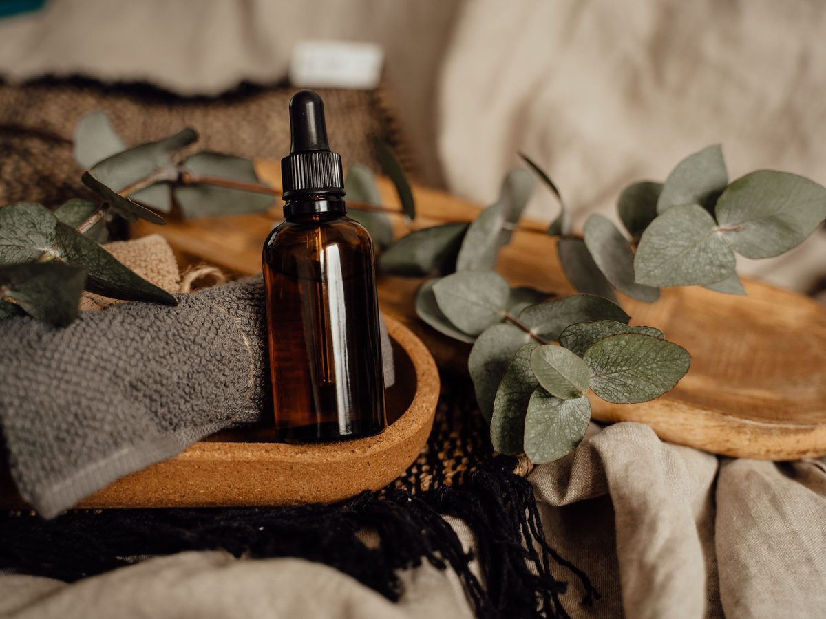 Massage oils, warm basalt stones and a eucalyptus sprig on the therapist's cart