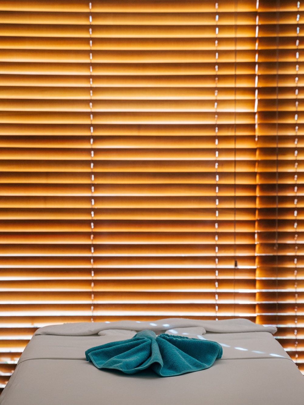A Stillwater massage room: dressed table, folded towel and a low lamp